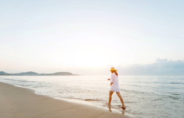 istock Woman walking on the beach 1065818618