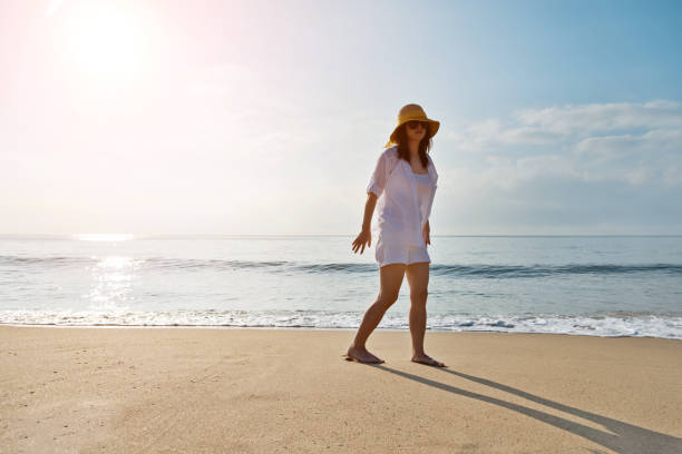 istock Young woman standing on beach 1065818868