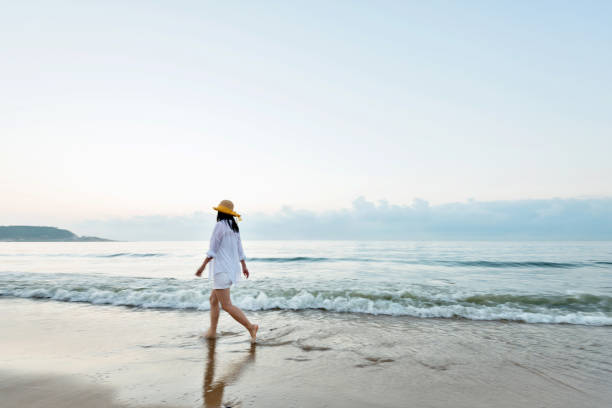 istock Woman walking on the beach 1065818896
