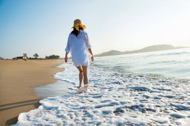 istock Woman walking on the beach 1065819032