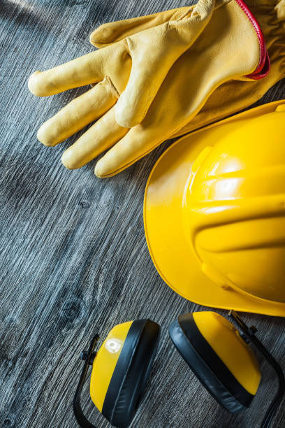 istock Protective gloves building helmet earmuffs on wooden board 1065819038