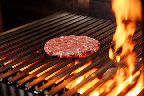 istock Chef making burger. Cooking hamburger. Beef or pork cutlet grilling on grid 1065819120