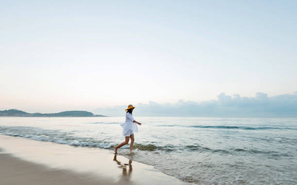 istock Woman walking on the beach 1065819180