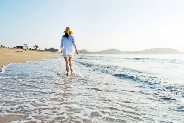 istock Woman walking on the beach 1065819426
