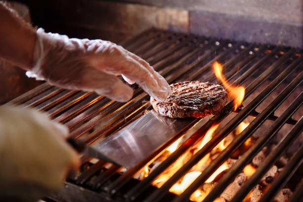 Chef making burger. Beef or pork meat barbecue burgers for hamburger prepared grilled on bbq fire flame grill. Close-up shot of chef's hands turn the chop on the grill Beef or pork meat barbecue burgers for hamburger prepared grilled on bbq fire flame grill metal grate photos stock pictures, royalty-free photos & images