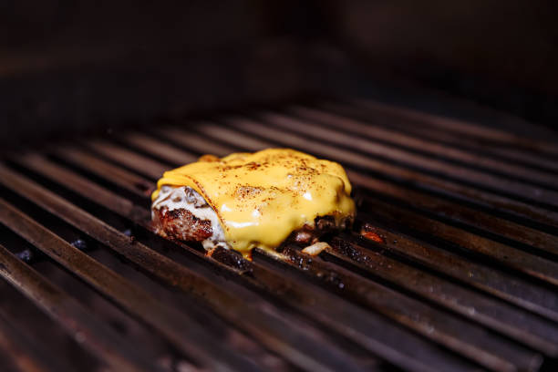 istock Chef making burger. Cooking hamburger. Beef or pork cutlet with cheese grilling on grid 1065819552