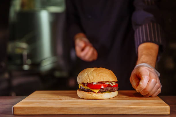 istock Chef putting bun on top,he making a beef burger for customer order 1065819814