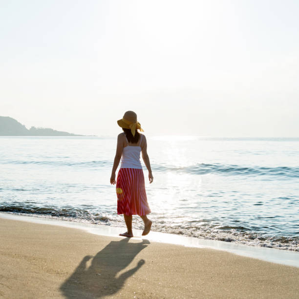 istock Woman walking on the beach 1065820030