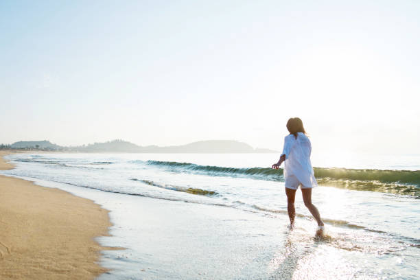 istock Woman walking on the beach 1065820256
