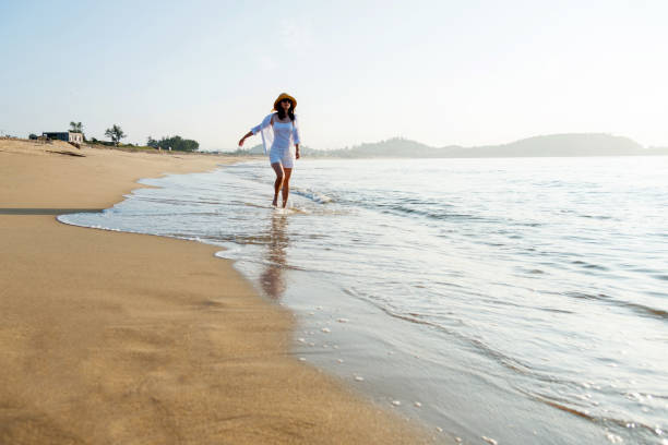 istock Happy woman walking on the beach 1065820628