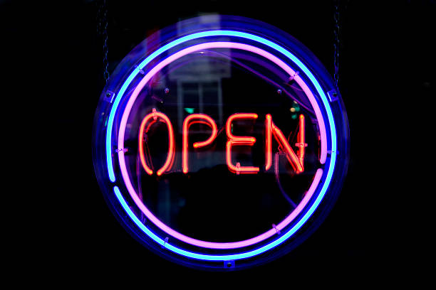 Neon sign at night with circle rings around it staying open stock photo