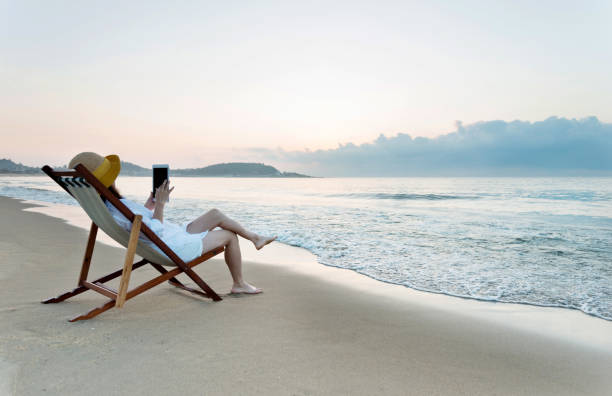 istock Woman using digital tablet at the beach 1065824546