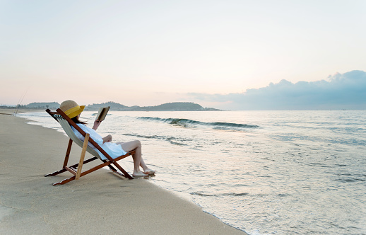 Woman reading book at the beach.