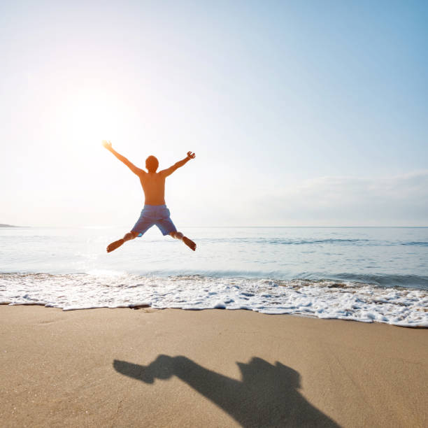istock Excited man jumping on the beach 1065824788