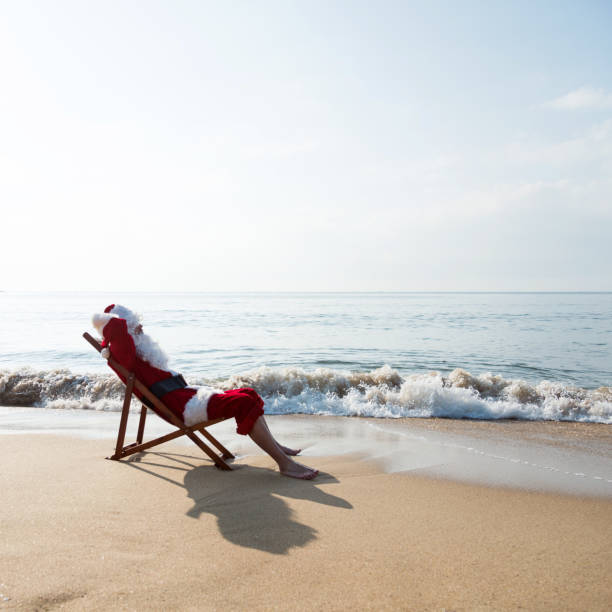 istock Santa Claus resting on deck chair at beach 1065827168