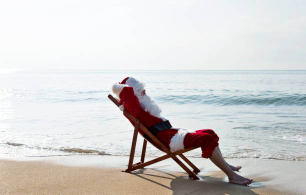istock Santa Claus resting on deck chair at beach 1065827288