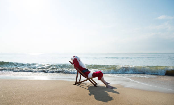 istock Santa Claus resting on deck chair at beach 1065827394