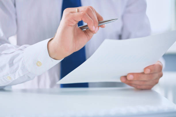 istock Serious business man working on documents and makes notes with a pen close-up. 1065827932