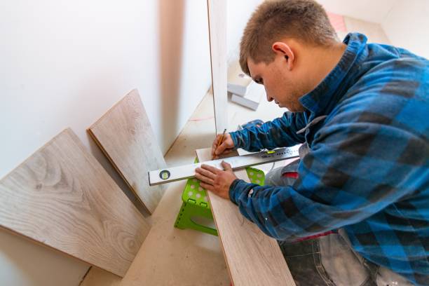 istock Man measuring and marking laminate floor tile for cutting, installing laminate flooring. 1065831940