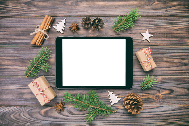istock Digital tablet mock up with rustic Christmas wooden vintage background decorations for app presentation. top view with copy space 1065835396