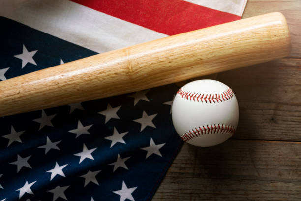 istock baseball and baseball bat with American flag in the background 1065835706