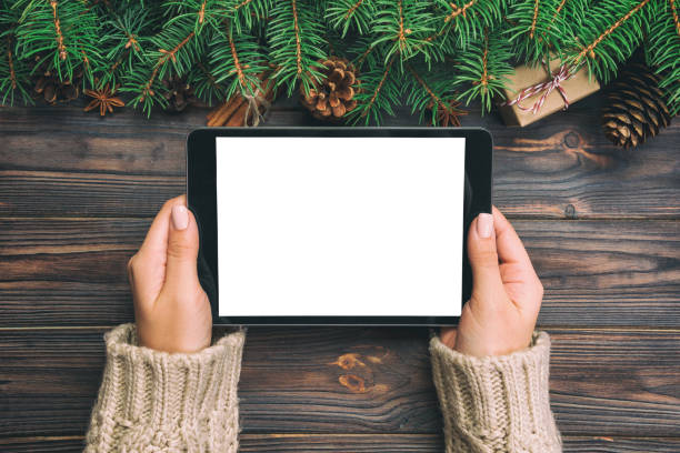 istock woman hands using tablet computer on wooden table bachground. cristmas shopping time. Happy Christmas mock up background, top view. vintage 1065835716
