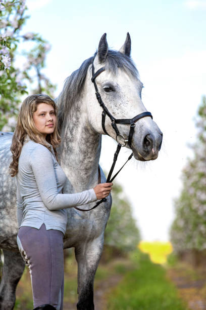 istock Young lady posing with a horse in the spring garden. 1065836368