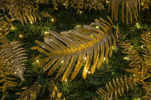 Christmas tree decoration fir-tree green in gold and green , leaves and branches with lighting