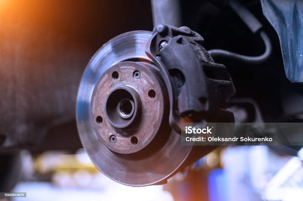 Caliper y disco de freno del coche de cerca sin la rueda de colores fríos con el hermoso contraluz - Foto de stock de Freno libre de derechos