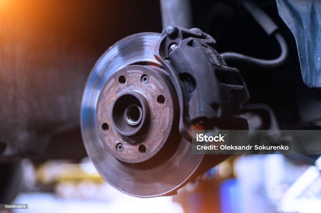 Car brake disk and caliper close up without wheel in cold colors with beautiful backlight Brake Stock Photo