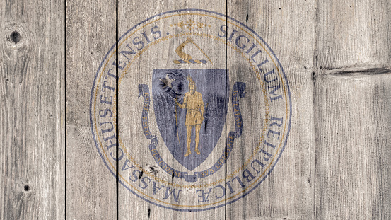 USA Politics News Concept: US State Massachusetts Seal Wooden Fence Background