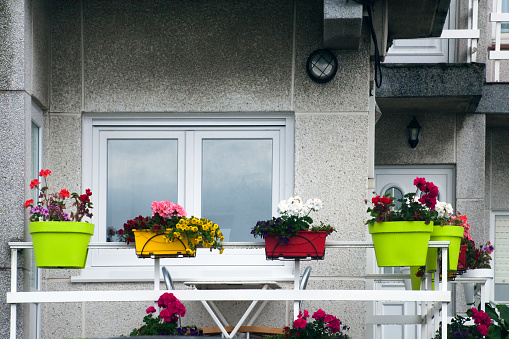Apartment balcony detail, multi colored flower pots. A Coruña, Galicia, Spain.