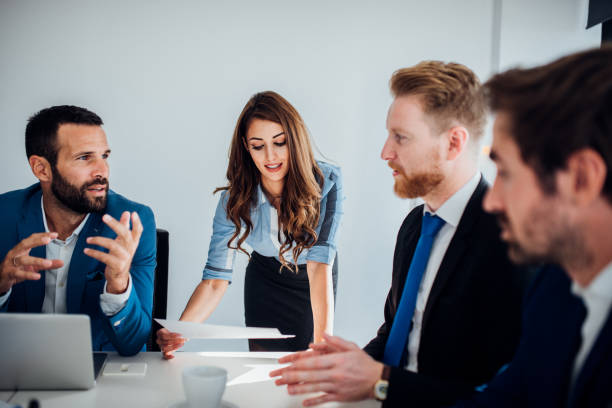 istock Young business people using laptop and talking 1065851870