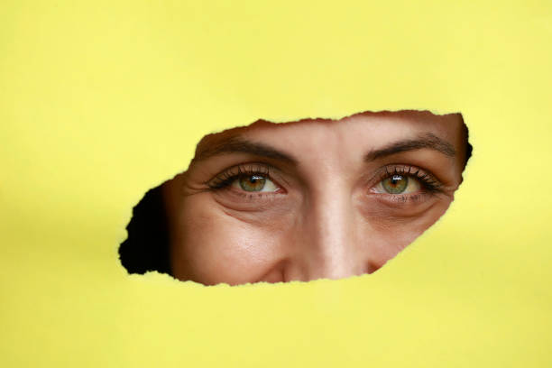 istock Girl watches through a hole in cardboard 1065856498