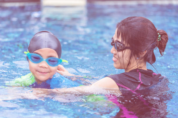 istock Mother is teaching her son to swim 1065857396