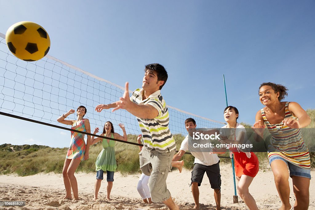 Teenage amigos jugando voleibol en la playa - Foto de stock de Vóleibol de playa libre de derechos