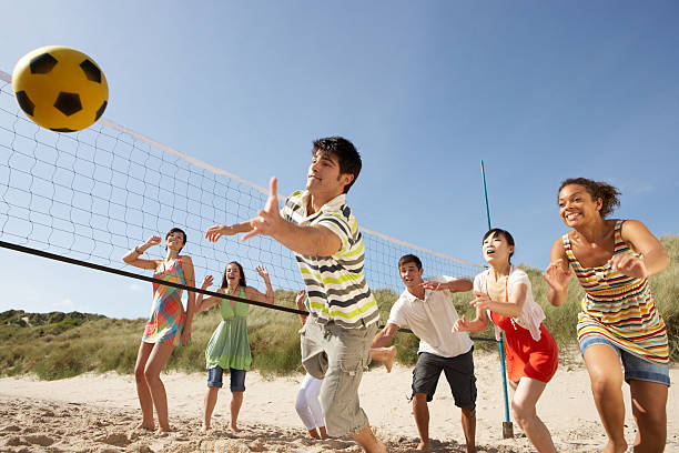 adolescente amigos jogando voleibol de praia - volleyball beach volleyball beach sport imagens e fotografias de stock