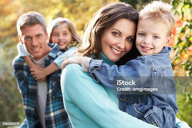 Smiling Family Of Four Portrait Outdoors In Autumn Stock Photo - Download Image Now - 30-39 Years, 4-5 Years, 8-9 Years