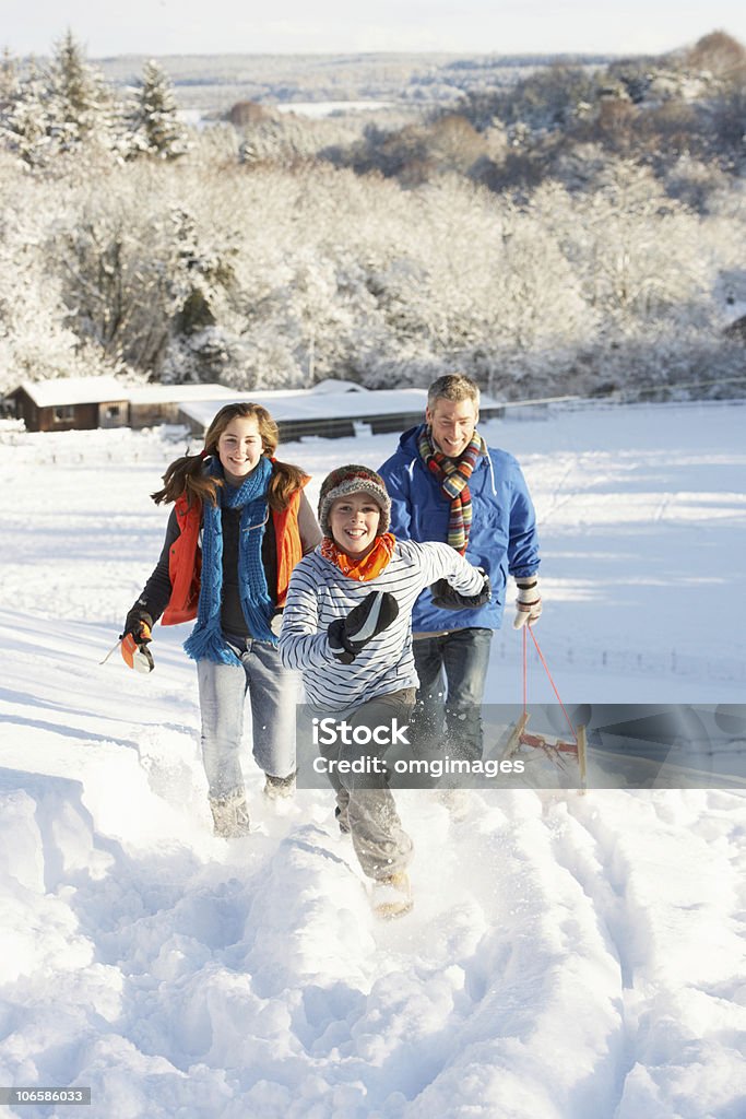 Padre de niños y extracción de trineo de nívea Hill - Foto de stock de Invierno libre de derechos