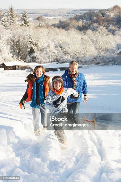 Foto de Pai E Filhos Puxando O Trenó De Neve Hill e mais fotos de stock de Inverno - Inverno, Neve, Andar de Tobogã