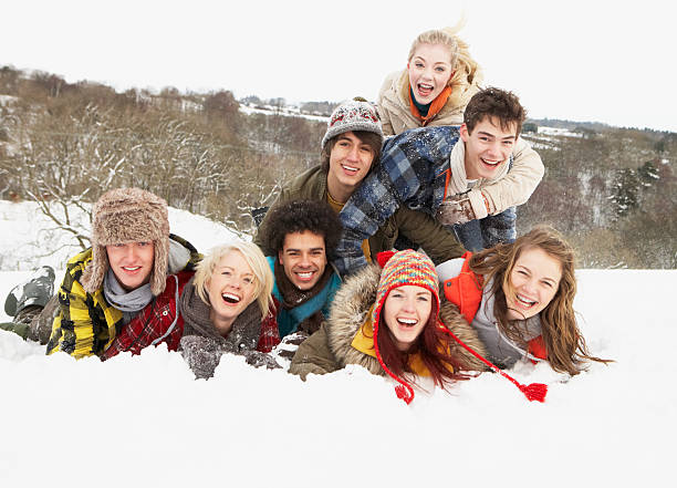 groupe de jeunes amis s'amusant dans un paysage enneigé - group of people teenager snow winter photos et images de collection