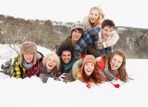 Group Of Teenage Friends Having Fun In Snowy Landscape Smiling At Camera