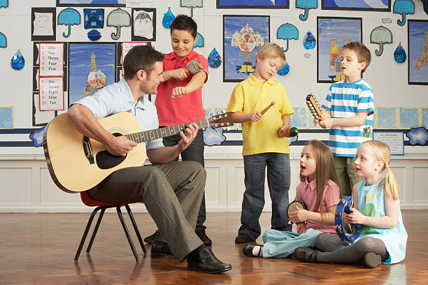 insegnante maschio con gli allievi che suona chitarra musica lezione - guitar child music learning foto e immagini stock