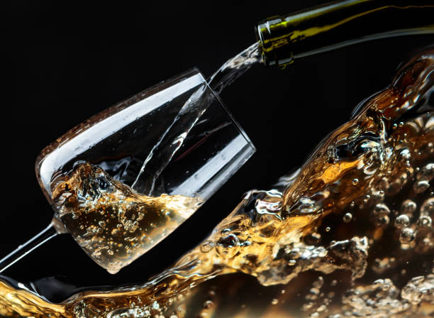 vinho branco sendo derramado em um copo de vinho. - champagne flute champagne black wineglass - fotografias e filmes do acervo