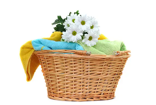 Photo of Fresh towels in a wooden basket with flowers