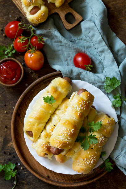 istock Sausage in Dough in rustic style on wooden table. Top view flat lay background. Copy space. 1065861634