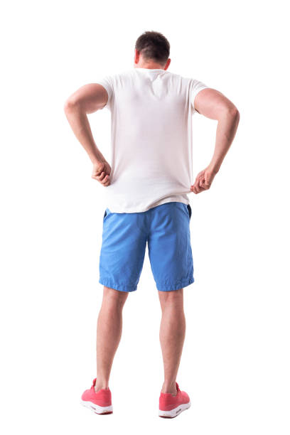 istock Back view of young handsome man adjusting and putting on summer clothes 1065865902