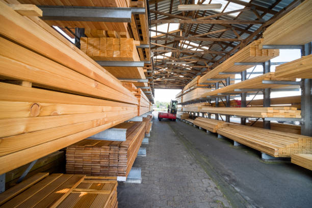 Racks with stacked wooden planks in warehouse stock photo