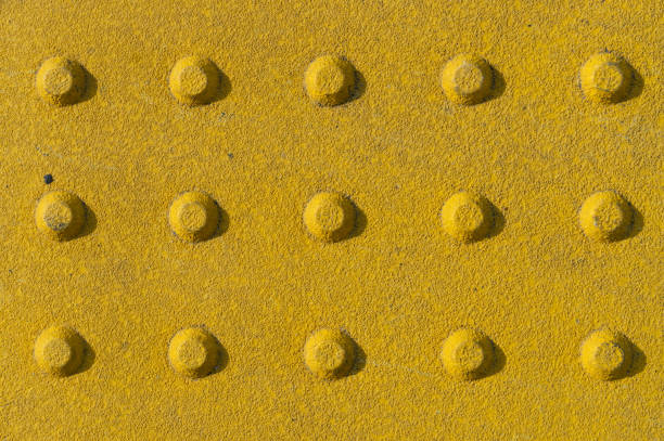texture de dalles de pavage tactile. yellow dot walk way, sécurité aveugle sur les trottoirs et les sentiers - yellow color image textured sensory perception photos et images de collection