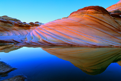 Water and quartz in rock bend light to create colors of rainbow.  Vermilion Cliffs National Monument.  Arizona, U.S.A.